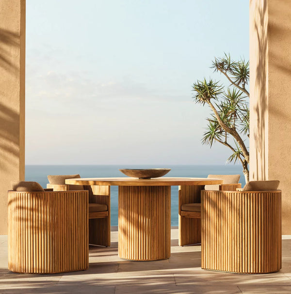 Moderno juego de comedor de teca para exterior: mesa redonda con base acanalada y sillones tipo barril.