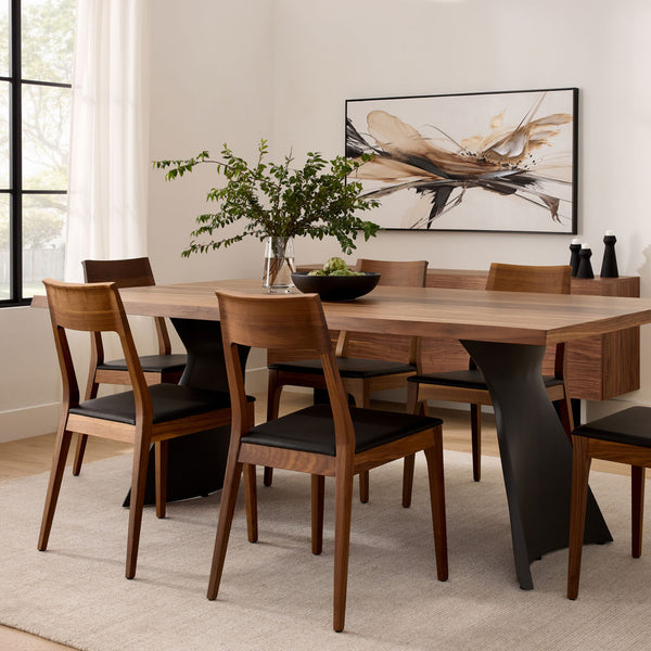 Juego de mesa de comedor moderno: base de pedestal escultural de madera negra y sillas con estructura de madera.