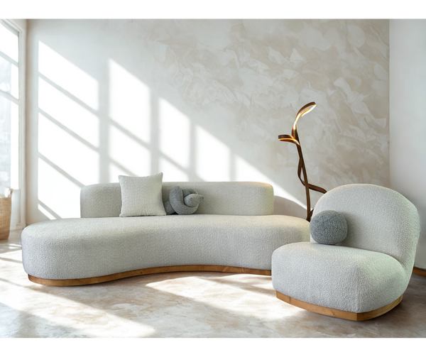 Moderno conjunto de sala de estar modular curvo: sofá beige escultural, sillones y mesa de centro redonda.