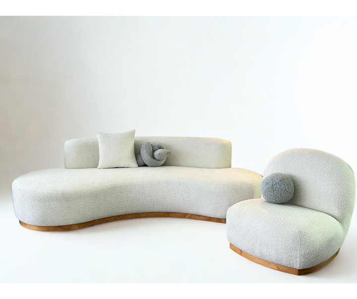 Modern curved sofa with cushions on a white background
