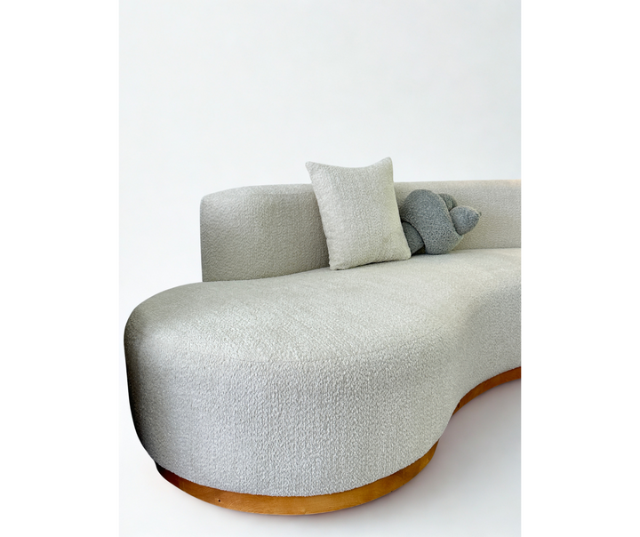 Modern gray sofa with wooden base on a white background