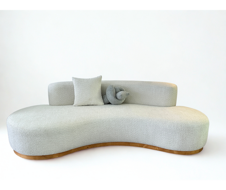 Modern light gray sofa with wooden base on a white background
