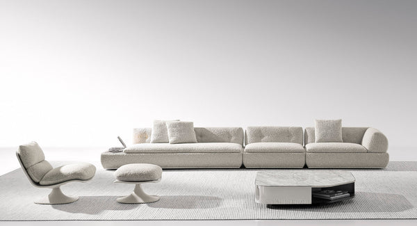 Sofá modular moderno de gran tamaño con chaise longue y mesa auxiliar integrada.