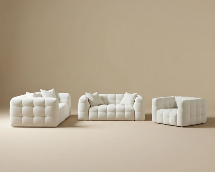 White tufted sofa set against a beige wall