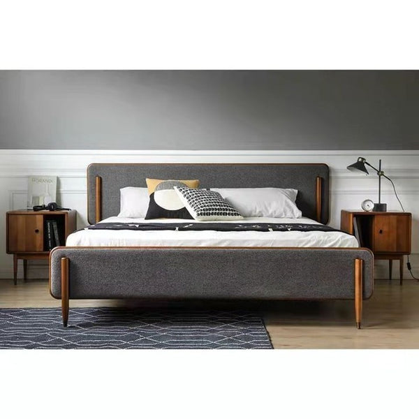 Cama tapizada moderna de mediados de siglo: estructura de madera maciza, tela gris y patas esculpidas.
