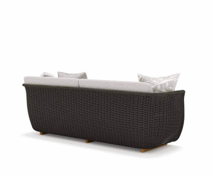 Dark wicker outdoor sofa with light cushions on a white background