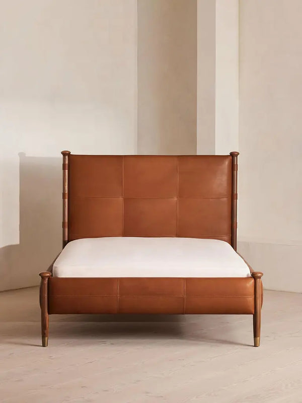 Cama moderna de mediados de siglo con paneles de cuero: estructura de madera maciza y patas con puntas de latón.