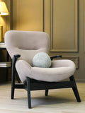 Taupe sculptural armchair black wood base and arm detail