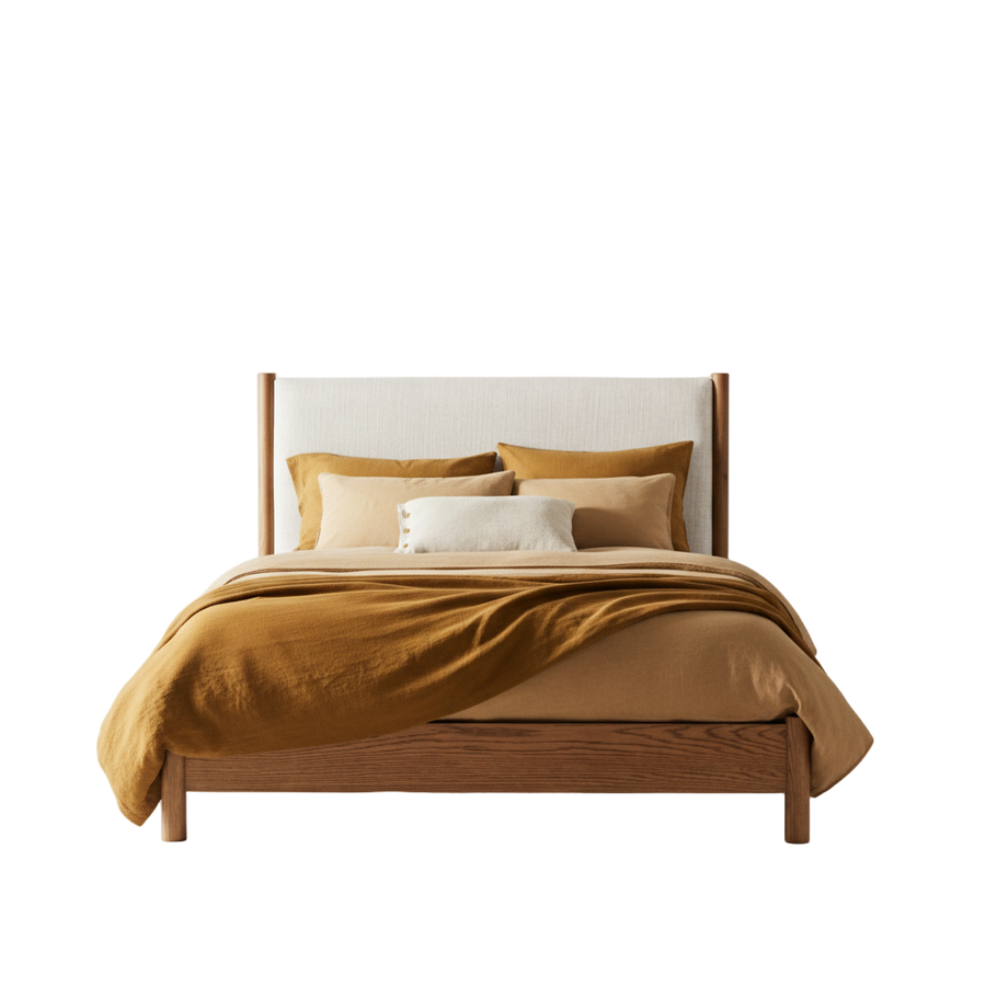 Wooden bed with mustard yellow bedding and pillows against a white background