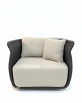 Modern armchair with beige cushions and dark woven frame on a white background